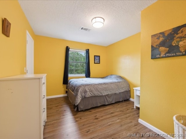 bedroom featuring a textured ceiling and hardwood / wood-style floors