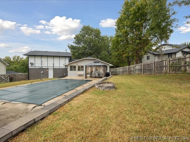 exterior space featuring a patio, a covered pool, a gazebo, and a yard