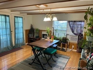 dining room featuring hardwood / wood-style floors, lofted ceiling with beams, and a chandelier