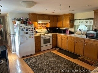 kitchen with light wood-type flooring, white appliances, and sink