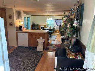 kitchen featuring kitchen peninsula, white appliances, and hardwood / wood-style flooring