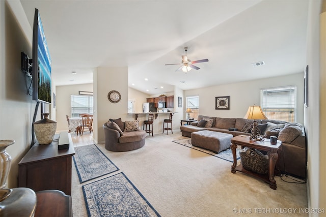 living room featuring lofted ceiling, light carpet, and ceiling fan