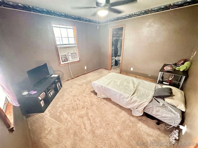 bedroom with a spacious closet, a closet, ceiling fan, and carpet floors