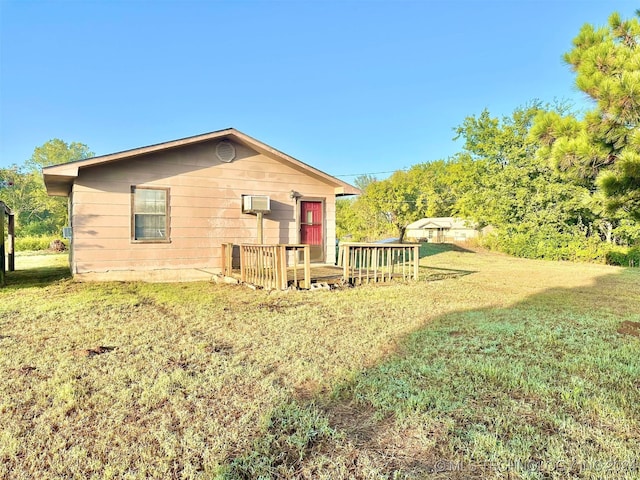 rear view of property featuring a yard and a wooden deck