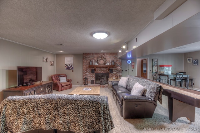 carpeted living room with a brick fireplace, a textured ceiling, and rail lighting