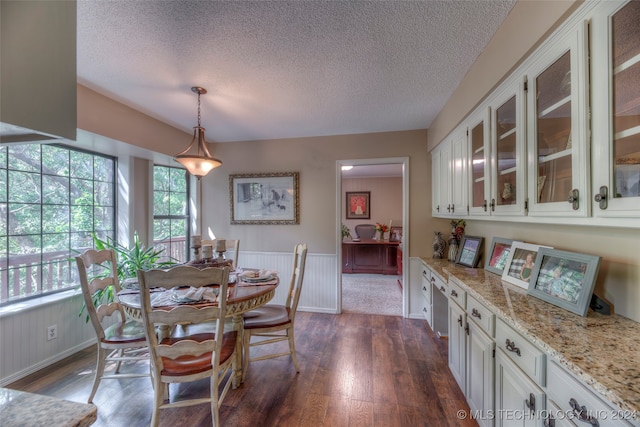 dining area featuring a textured ceiling and dark hardwood / wood-style floors