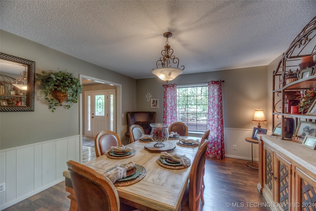 dining room featuring a textured ceiling and dark hardwood / wood-style flooring