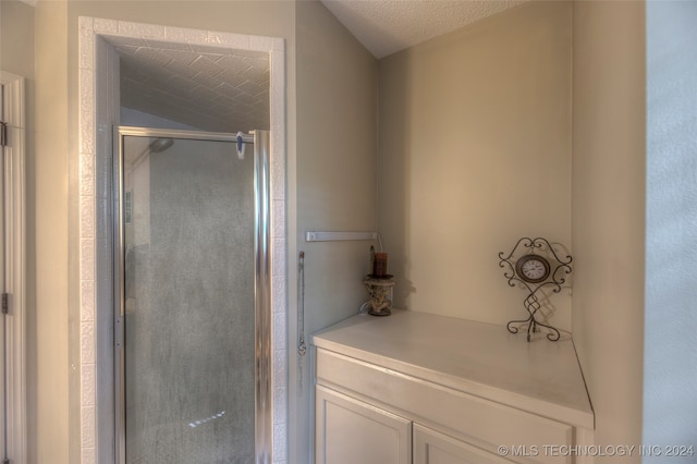 bathroom featuring a textured ceiling and a shower with door