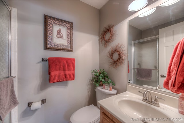 bathroom featuring walk in shower, vanity, and toilet