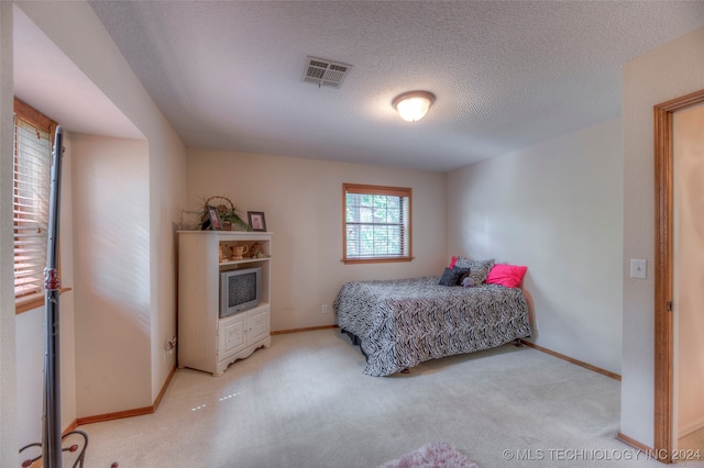 carpeted bedroom featuring a textured ceiling