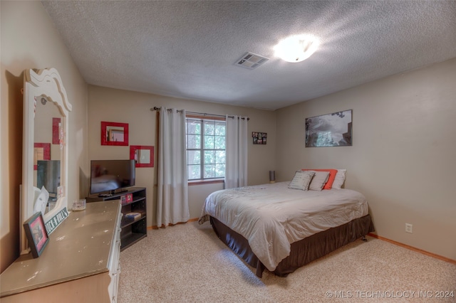 bedroom with a textured ceiling and carpet floors