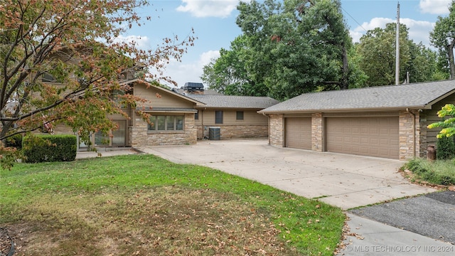 view of front of property with cooling unit, a garage, and a front lawn