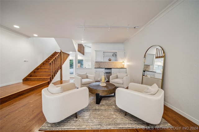 living room featuring crown molding, hardwood / wood-style flooring, and rail lighting