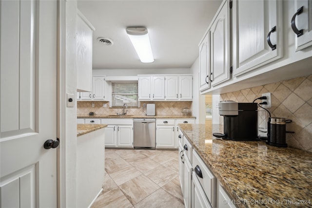 kitchen with light stone counters, white cabinets, dishwasher, and tasteful backsplash