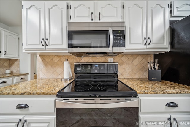 kitchen featuring appliances with stainless steel finishes, tasteful backsplash, light stone countertops, and white cabinets