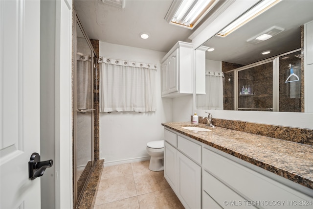 bathroom featuring walk in shower, vanity, toilet, and tile patterned floors