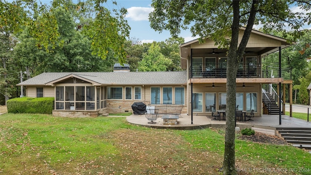 rear view of property with a wooden deck, a patio, a fire pit, a sunroom, and ceiling fan