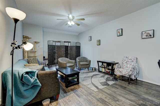 living room with ceiling fan, hardwood / wood-style flooring, and a textured ceiling