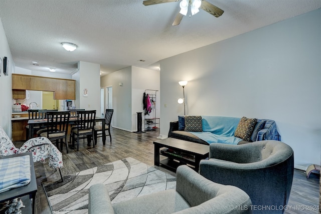 living room with a textured ceiling, hardwood / wood-style floors, and ceiling fan