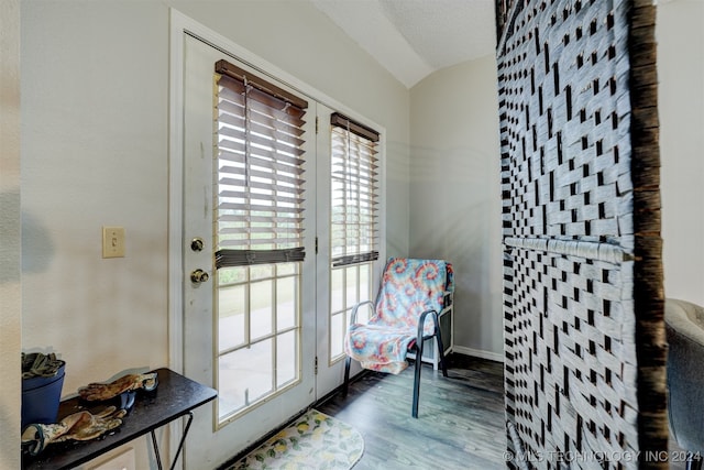 entryway with lofted ceiling, a textured ceiling, and hardwood / wood-style floors