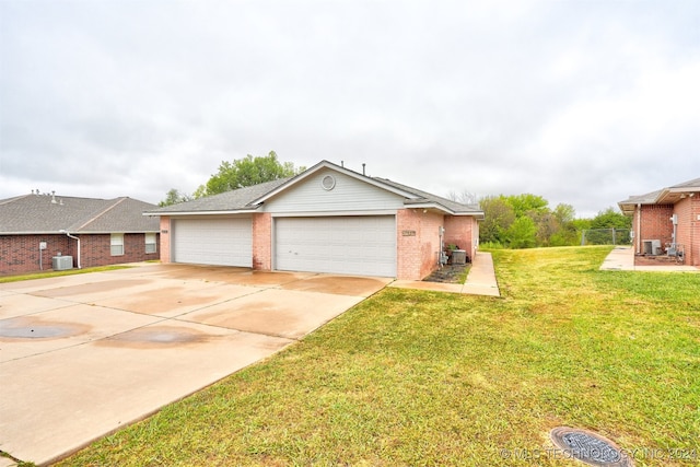 view of front of house featuring a front yard, a garage, and central AC unit