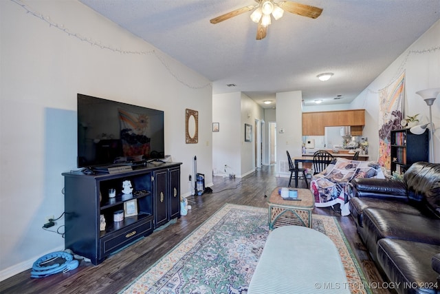 living room with ceiling fan, a textured ceiling, and dark hardwood / wood-style flooring