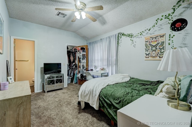 bedroom featuring a closet, a textured ceiling, vaulted ceiling, light carpet, and ceiling fan