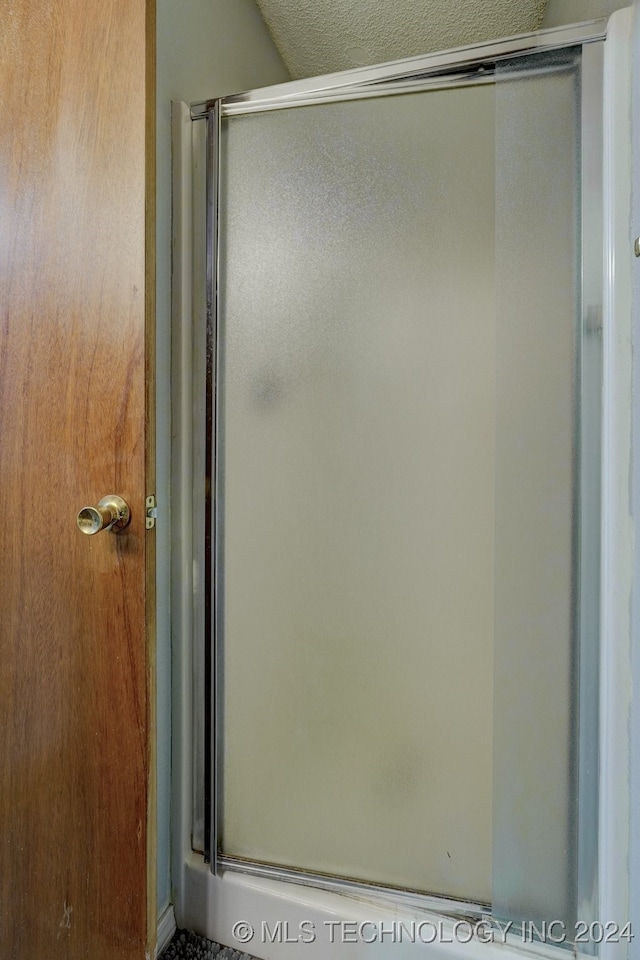 bathroom with a shower with door