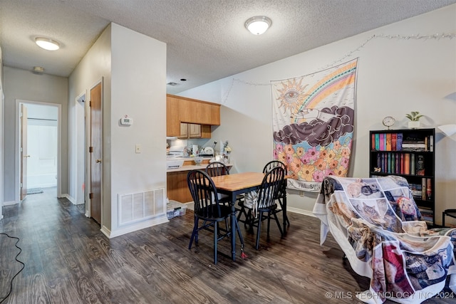 dining space with a textured ceiling and dark hardwood / wood-style flooring