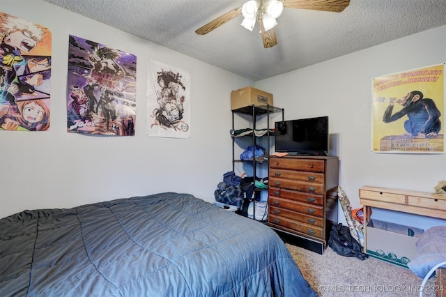 carpeted bedroom featuring ceiling fan and a textured ceiling