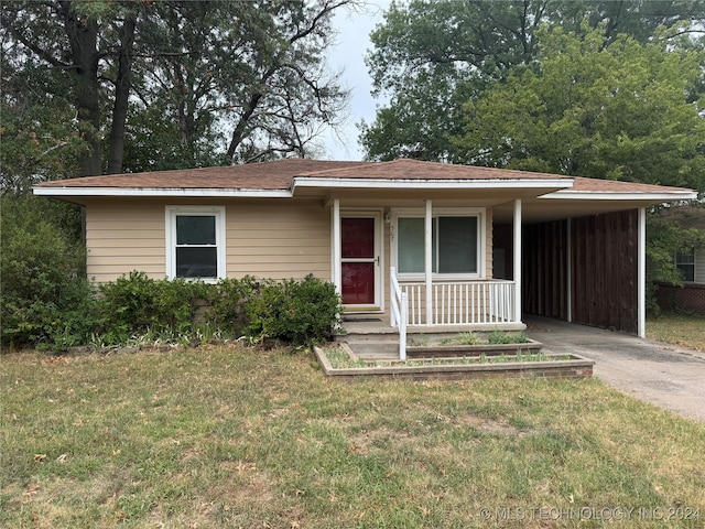 view of front of home with a carport, a front yard, and covered porch