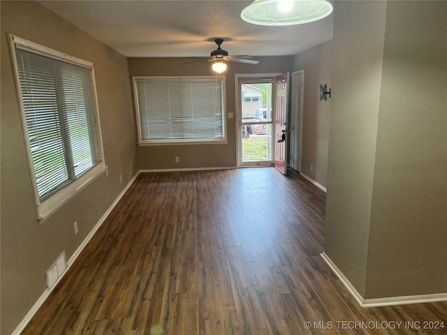 empty room with ceiling fan and dark wood-type flooring