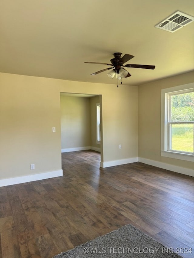 empty room featuring dark wood-type flooring and ceiling fan