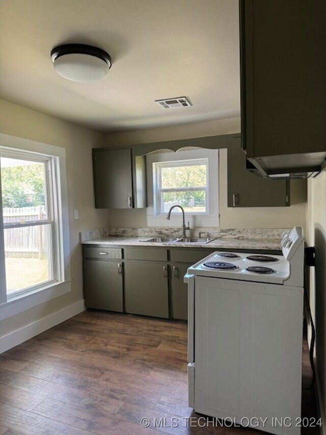 kitchen featuring white electric range oven, dark hardwood / wood-style floors, and a healthy amount of sunlight