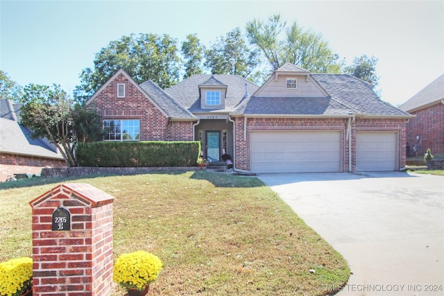 view of front of property with a front lawn and a garage