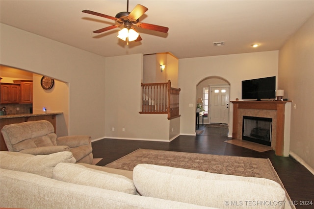 living room featuring ceiling fan and dark wood-type flooring