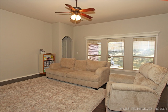 living room featuring ceiling fan and dark hardwood / wood-style floors