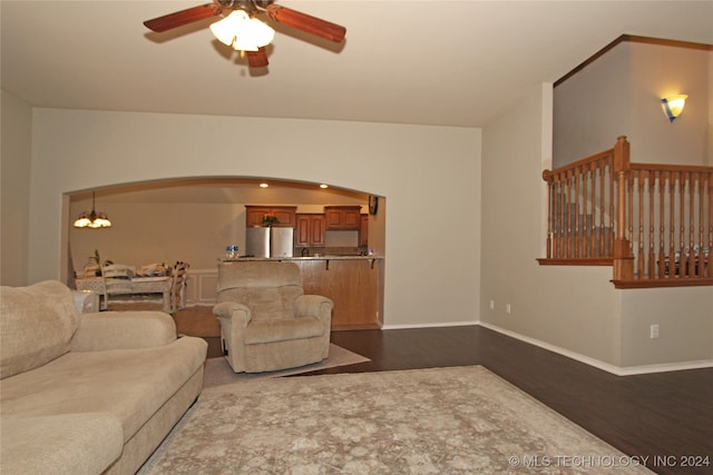 living room featuring ceiling fan with notable chandelier and hardwood / wood-style flooring