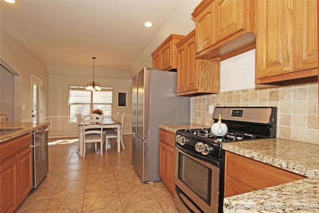 kitchen featuring pendant lighting, an inviting chandelier, backsplash, appliances with stainless steel finishes, and light tile patterned floors