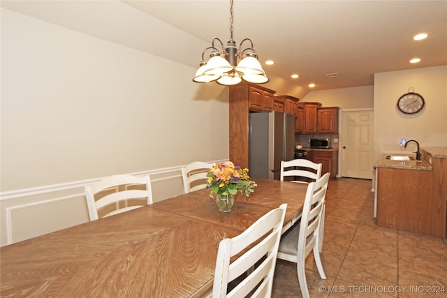 dining space featuring sink, light tile patterned floors, and a notable chandelier