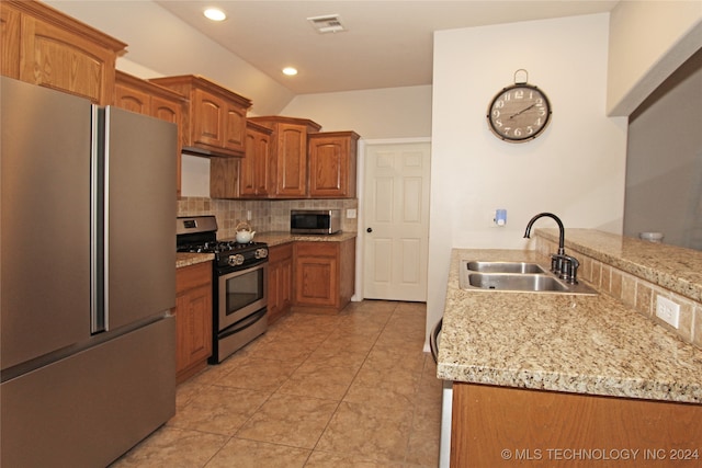 kitchen featuring sink, kitchen peninsula, decorative backsplash, stainless steel appliances, and light tile patterned floors