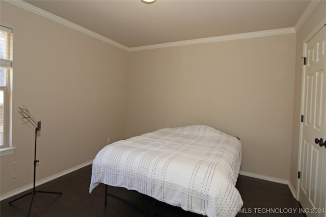 bedroom with ornamental molding and dark colored carpet