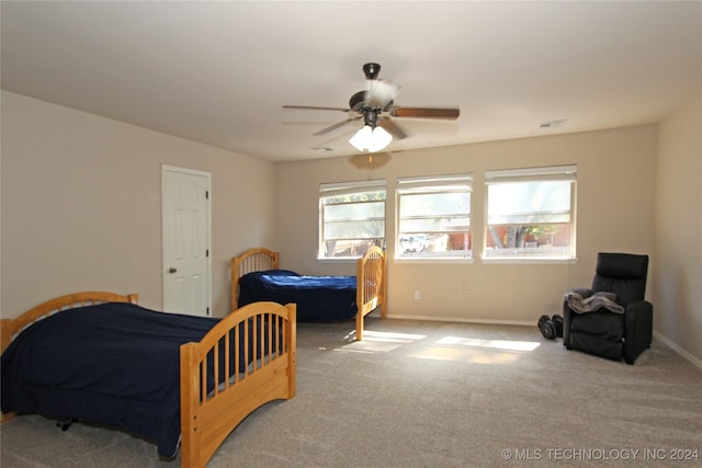 carpeted bedroom featuring ceiling fan and multiple windows