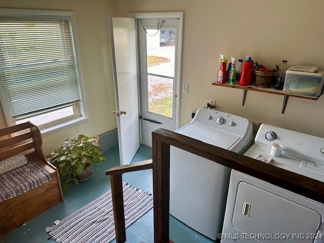 clothes washing area featuring plenty of natural light and washer and dryer