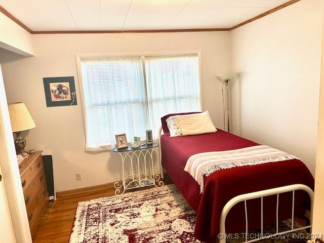 bedroom with crown molding and hardwood / wood-style floors