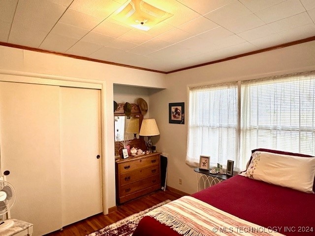 bedroom featuring ornamental molding and dark wood-type flooring