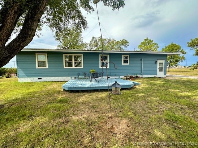 back of property with a lawn and a wooden deck