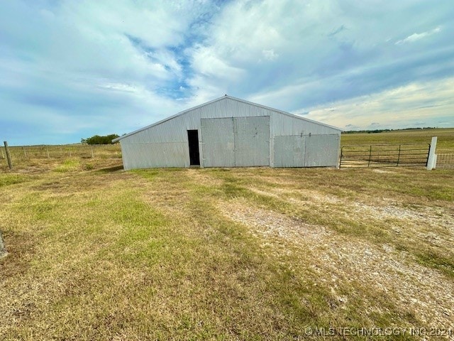 view of outdoor structure with a yard and a rural view