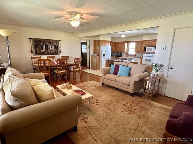 living room with light wood-type flooring and ceiling fan