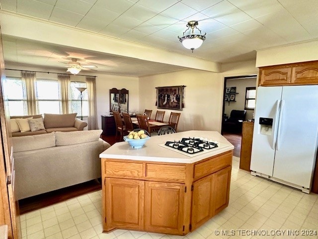 kitchen with white appliances, ceiling fan, and a center island